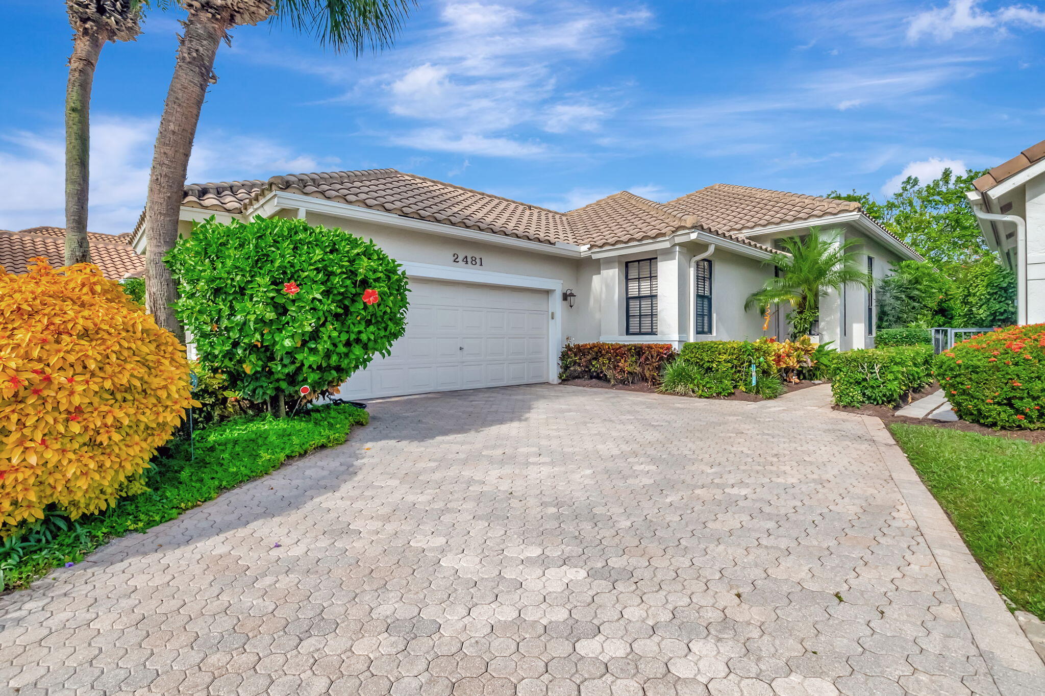 a view of a house with a yard and potted plants