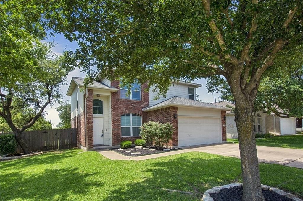 a view of a house with a yard and tree