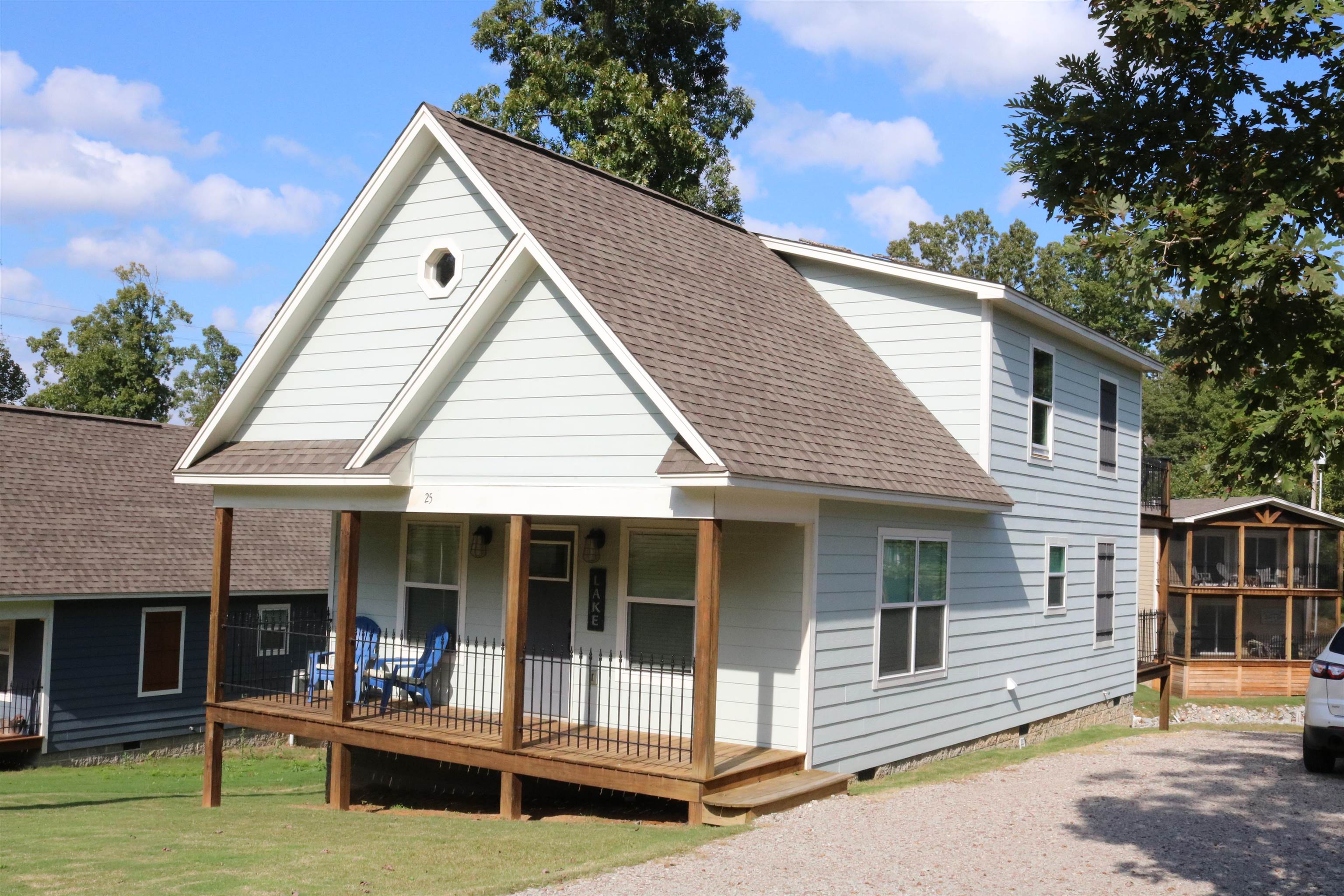 a view of house with outdoor seating and covered with trees