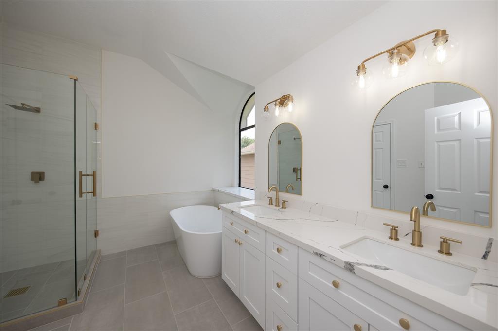 a spacious bathroom with a double vanity sink mirror and shower