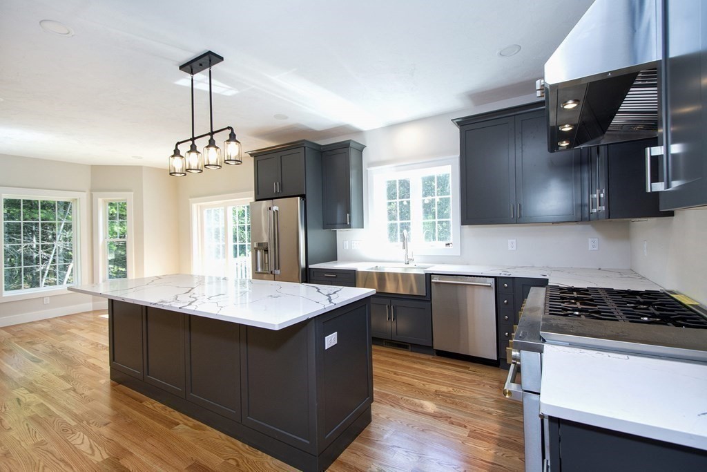 a kitchen with stainless steel appliances granite countertop a sink stove and refrigerator