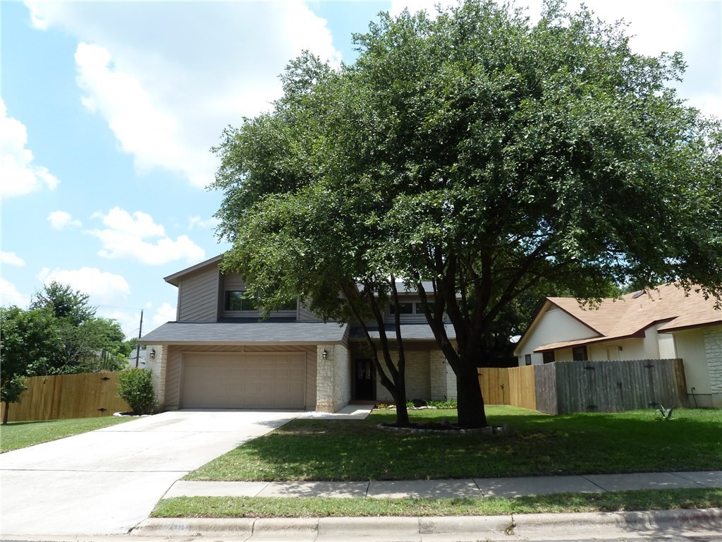 a front view of a house with a yard and trees