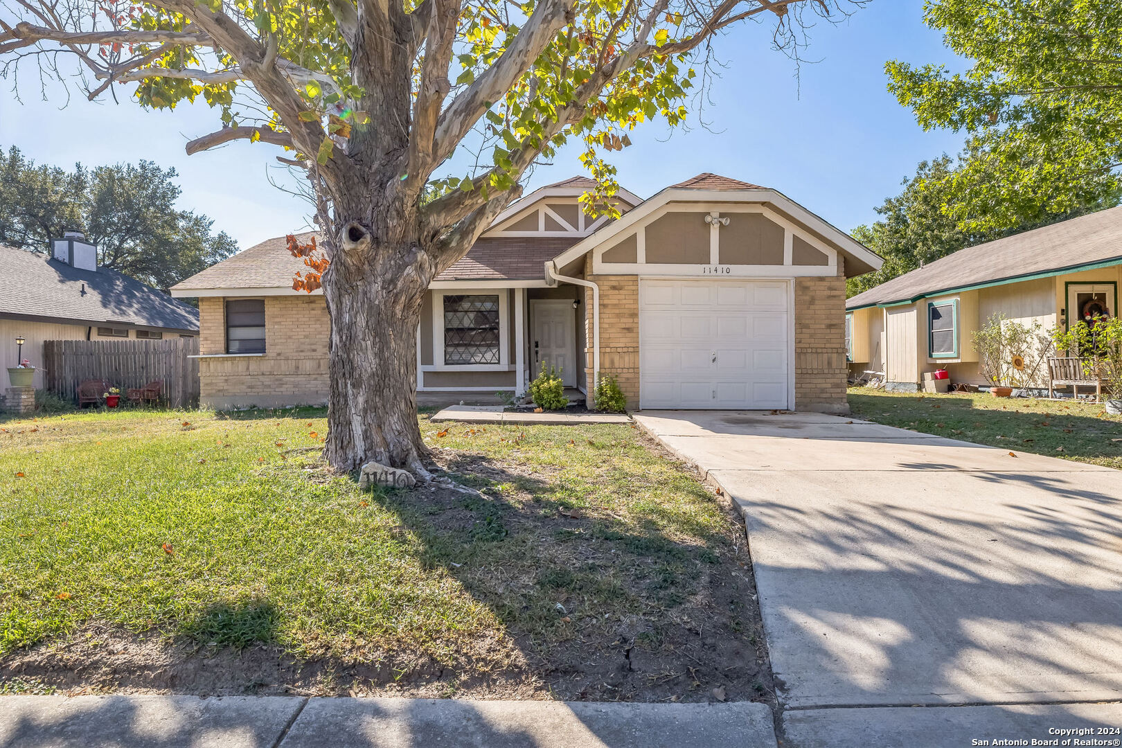 a front view of a house with a yard and trees