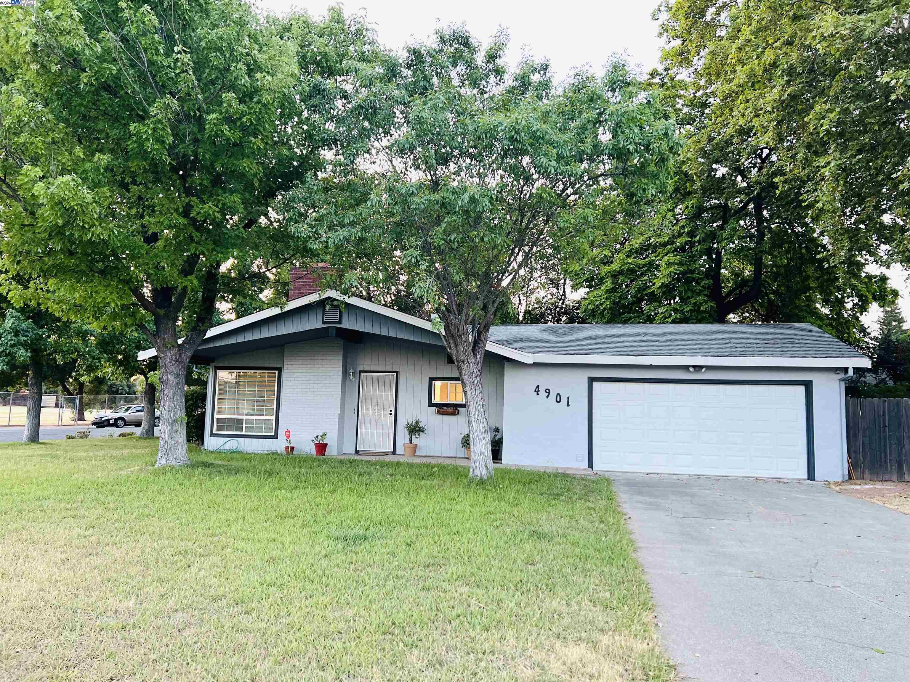 a front view of a house with a garden and yard