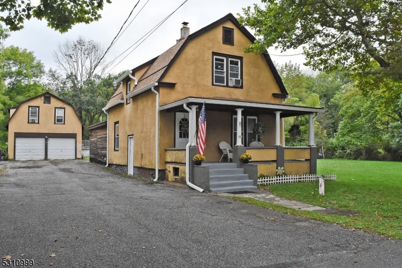 a view of a house with a yard and large tree