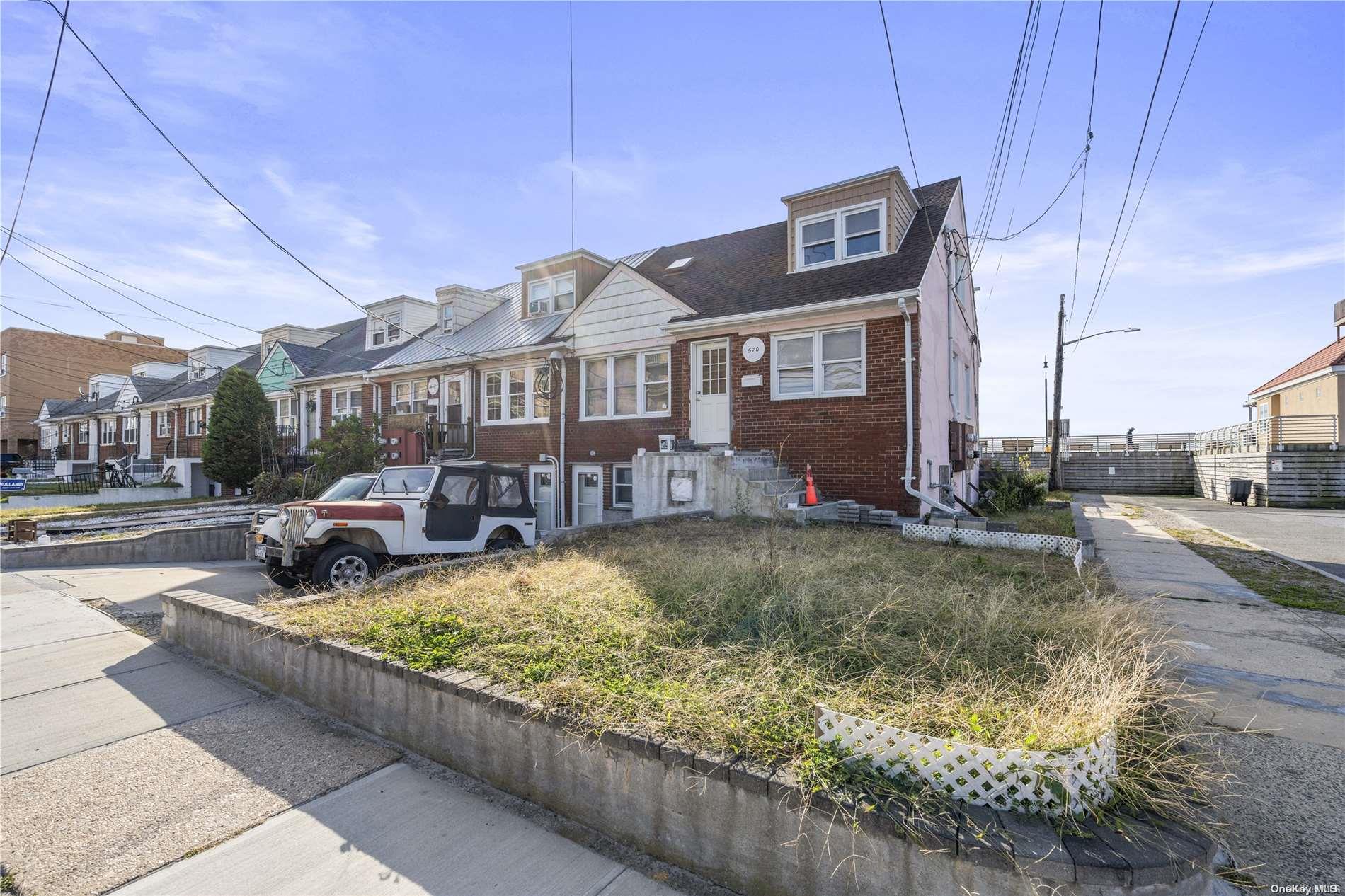 a view of a brick house with many windows next to a road