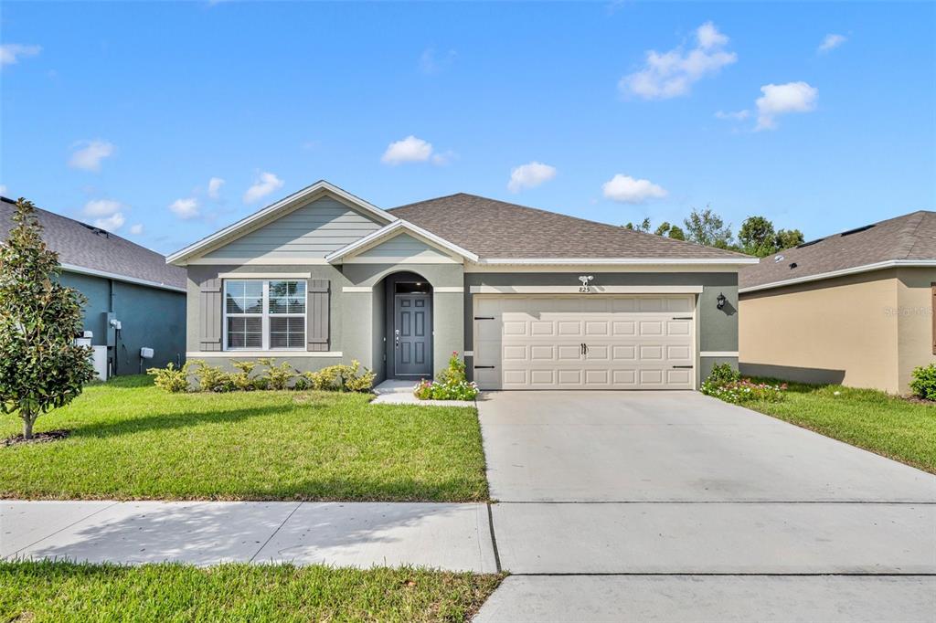 a front view of a house with a yard and garage