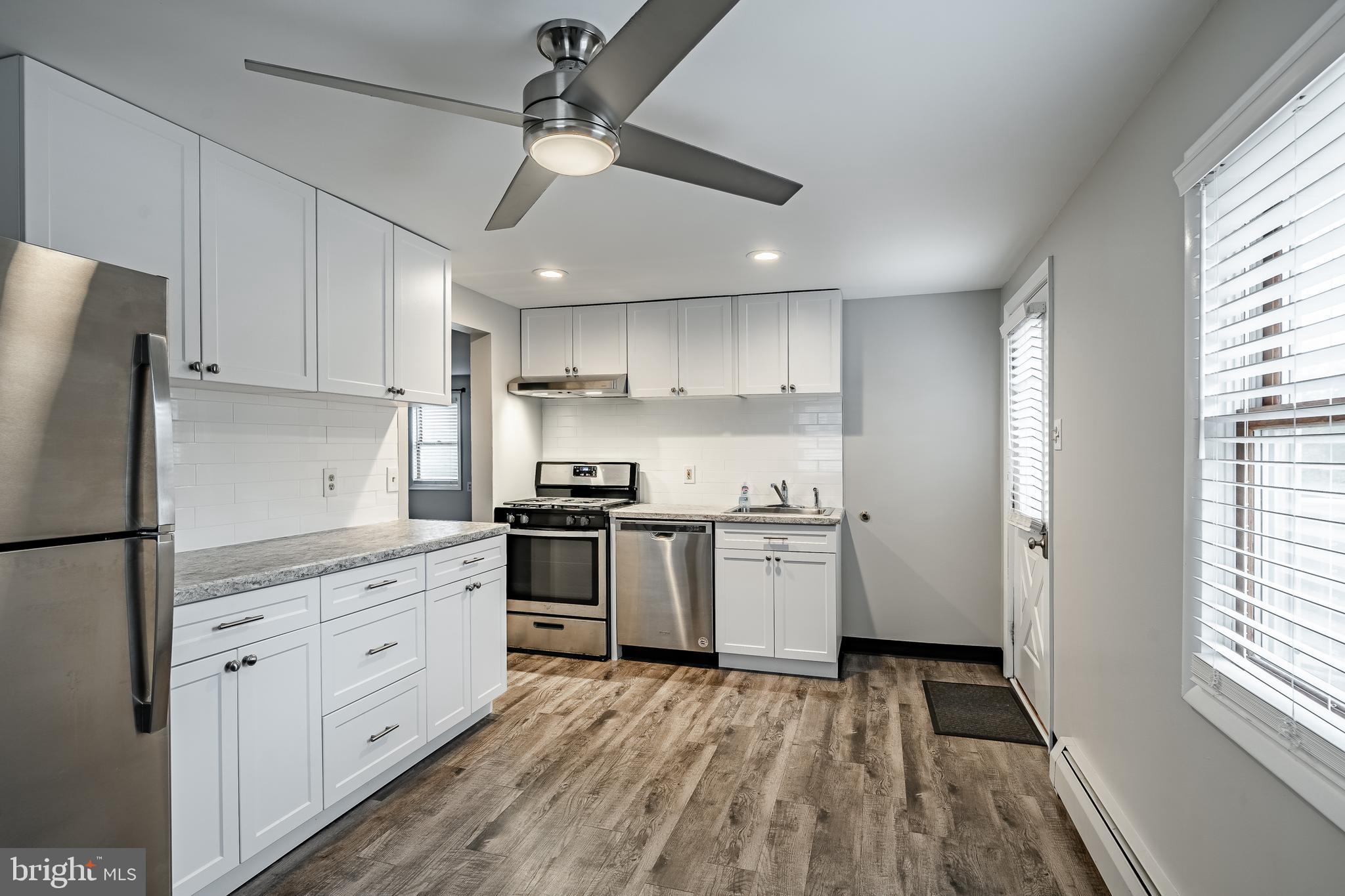 a kitchen with granite countertop white cabinets and white appliances