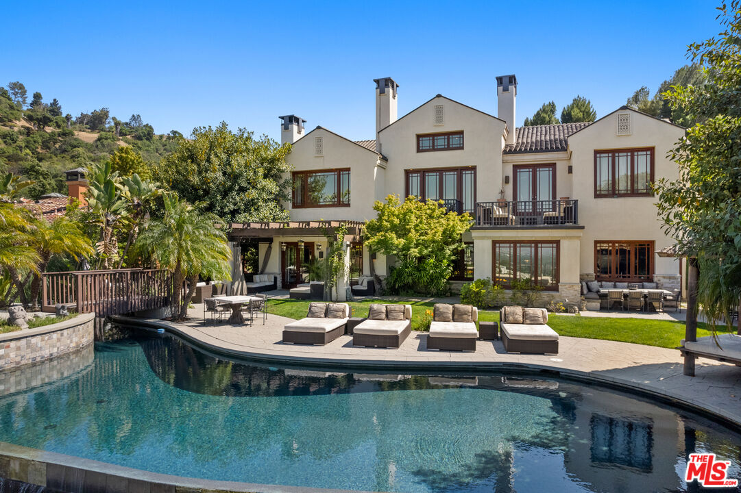 a view of a house with pool and chairs