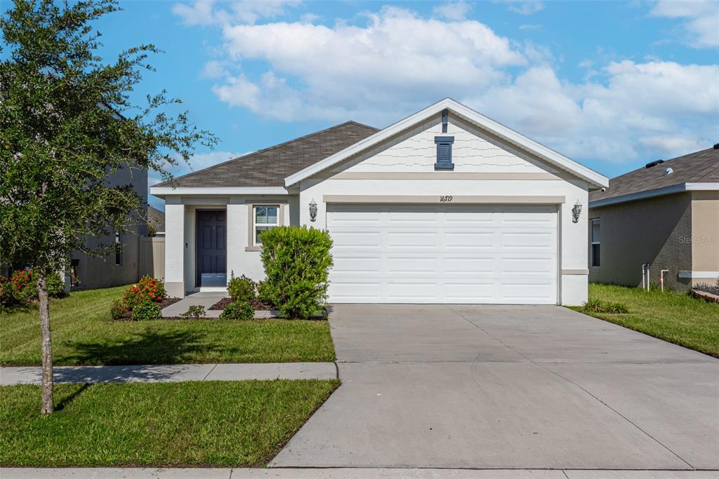 a view of a house with garage and plants