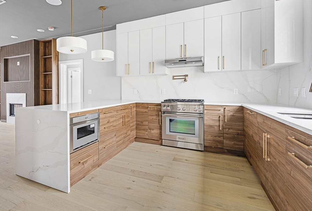 a kitchen with stainless steel appliances granite countertop a refrigerator and a stove