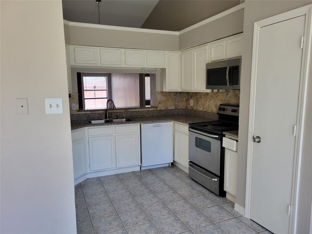 a kitchen with a sink stove and cabinets