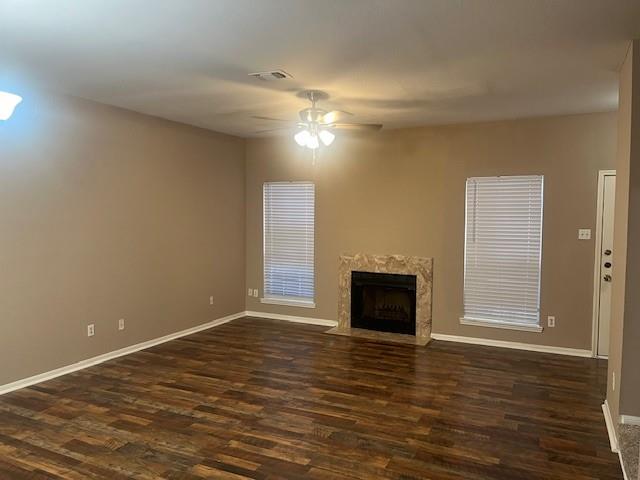 a view of an empty room with wooden floor fireplace and a window