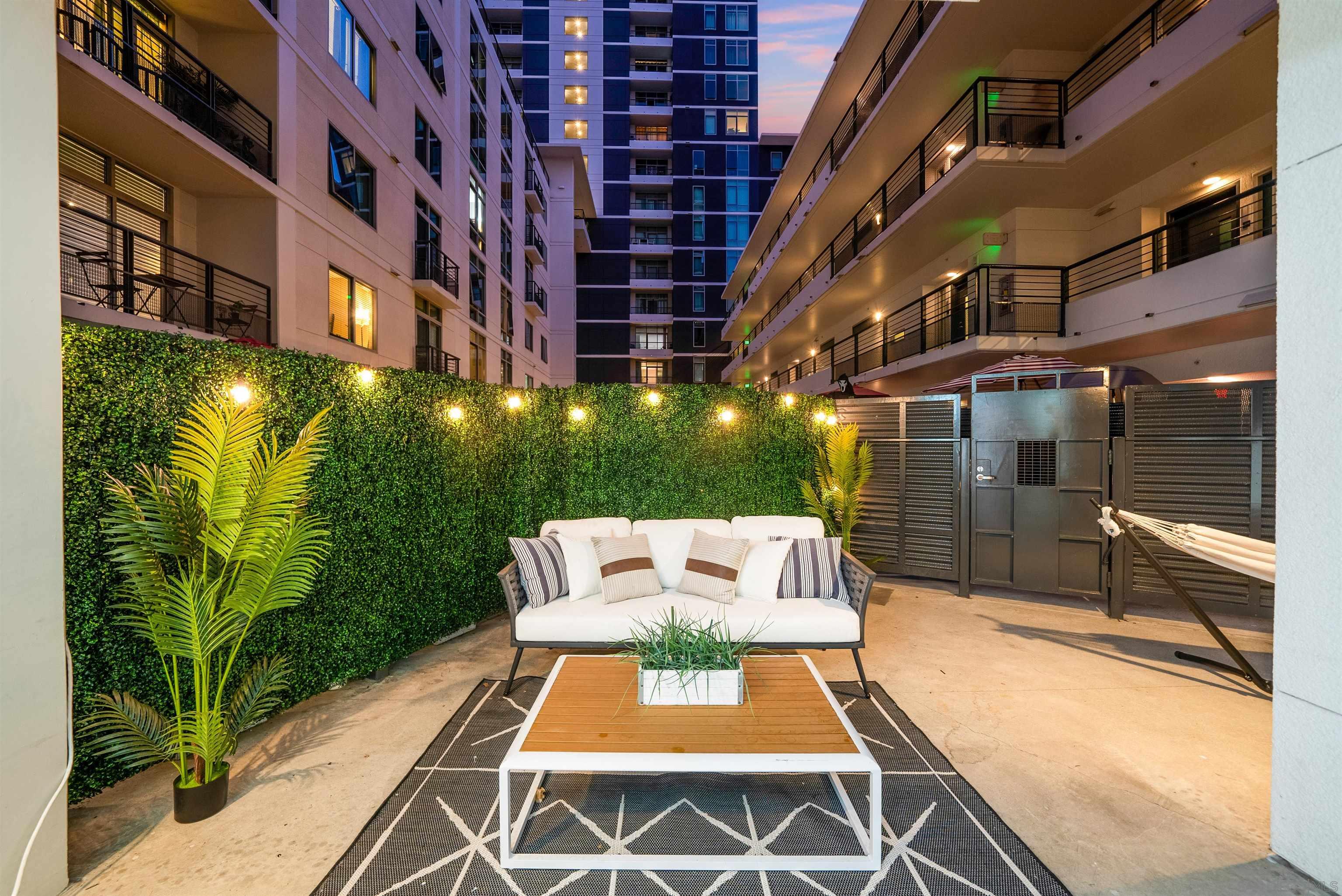 a view of a patio with couches table and chairs and potted plants