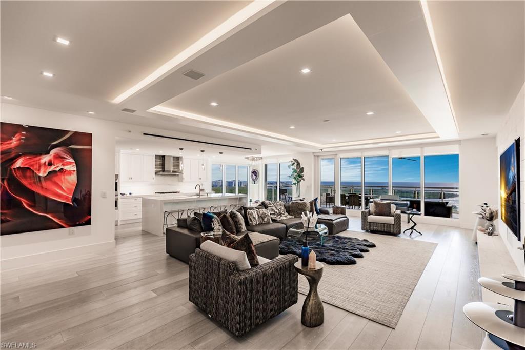 a living room with furniture kitchen view and a large window