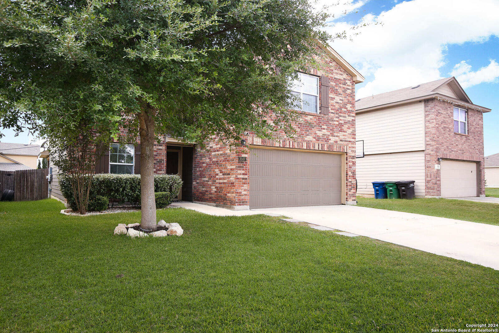 a view of a house with a yard and tree