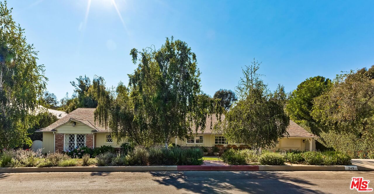 a front view of a house with a yard and trees