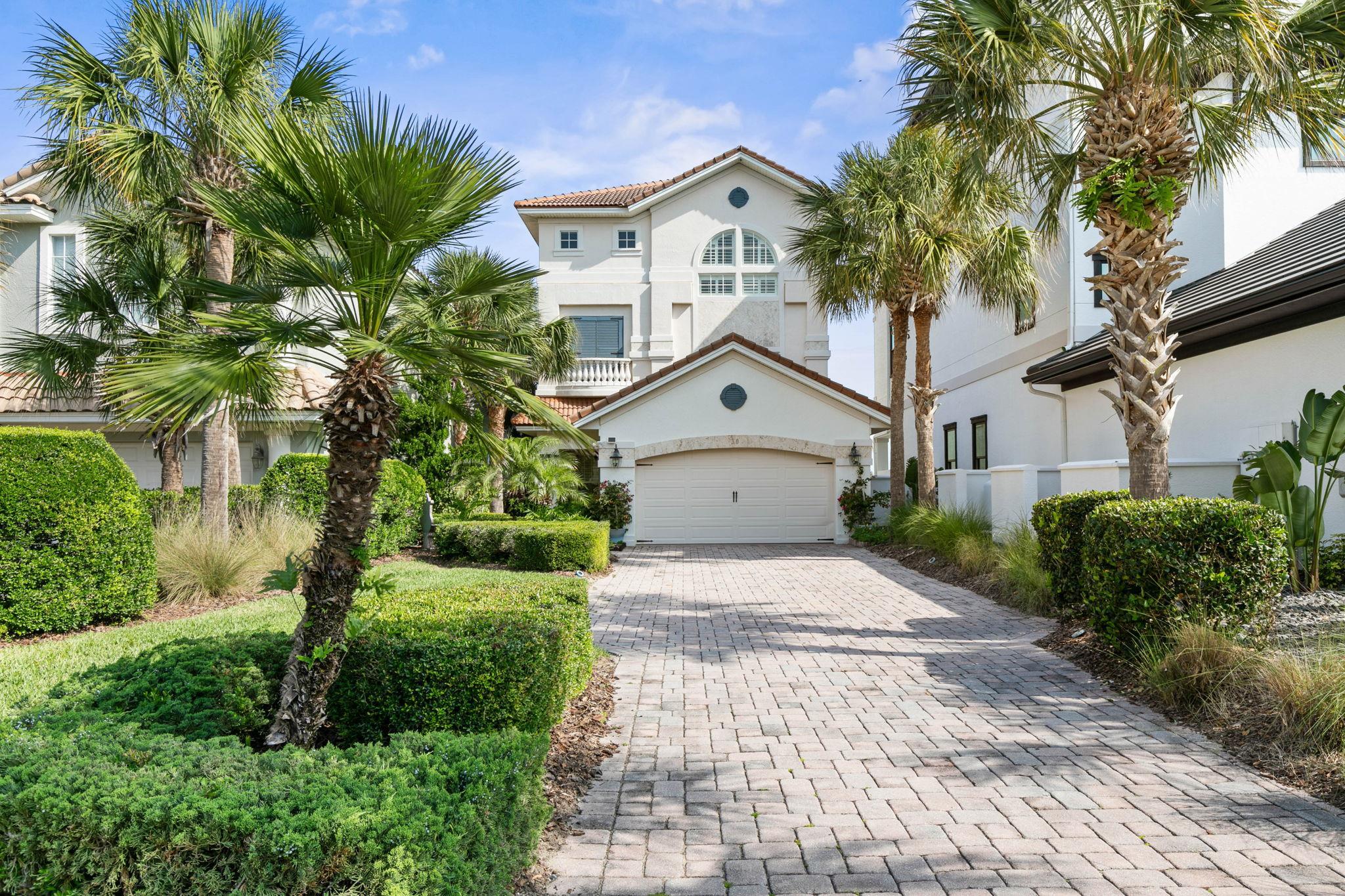 a front view of a house with a yard and trees