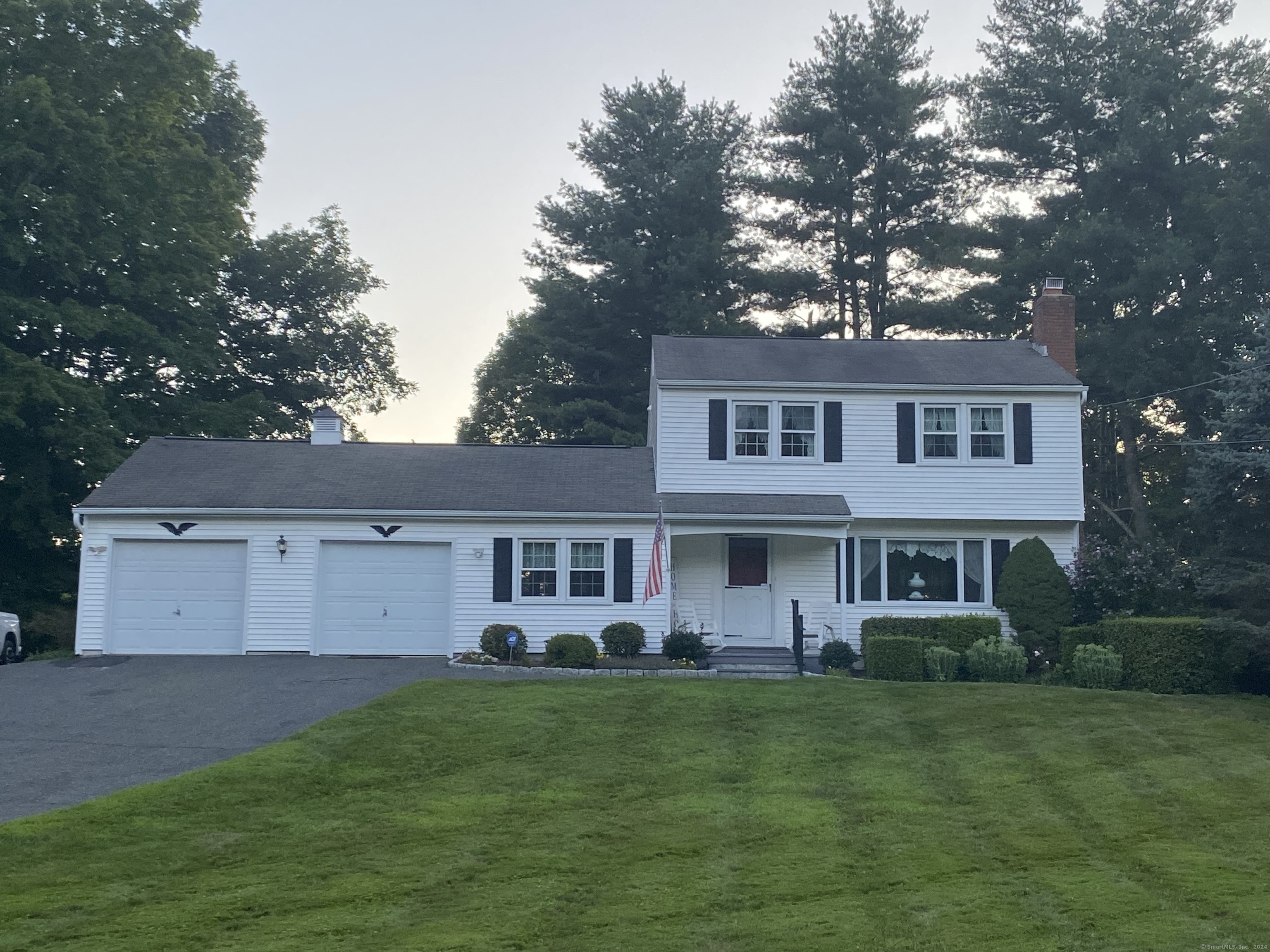 a front view of a house with a yard and trees