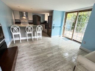 a view of a dining room with furniture a chandelier and wooden floor