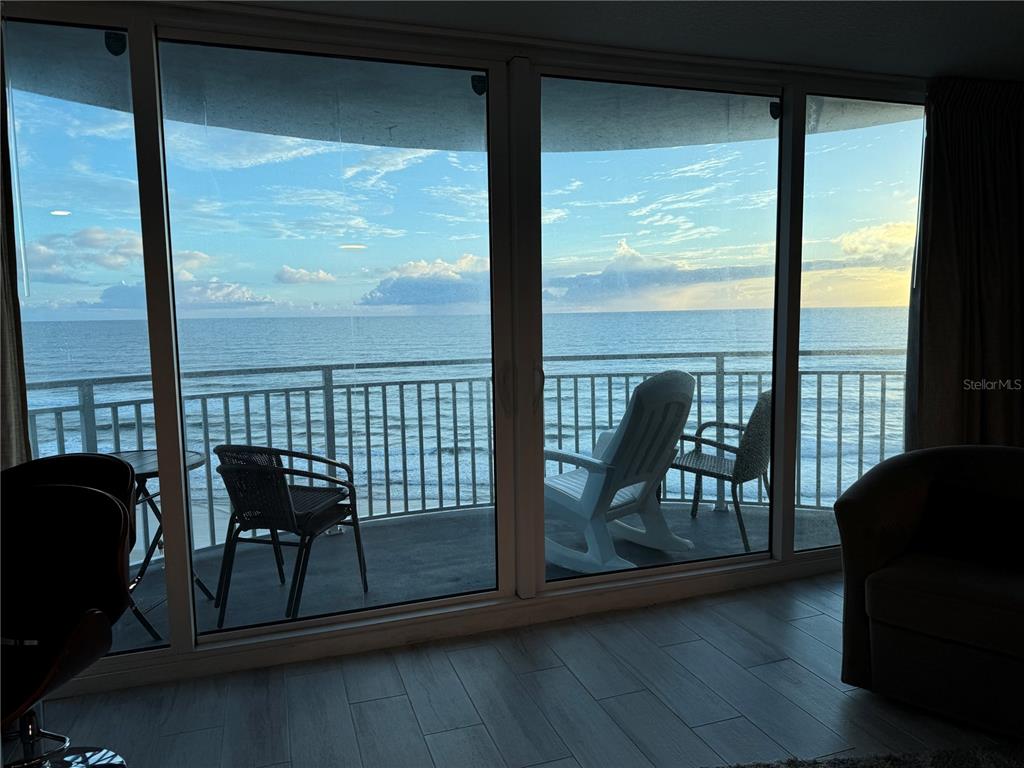 a view of a balcony with chairs and wooden floor