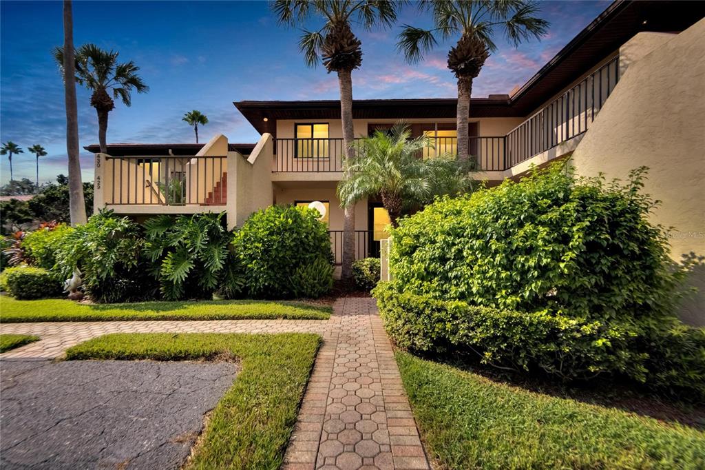 a view of a house with a yard and potted plants