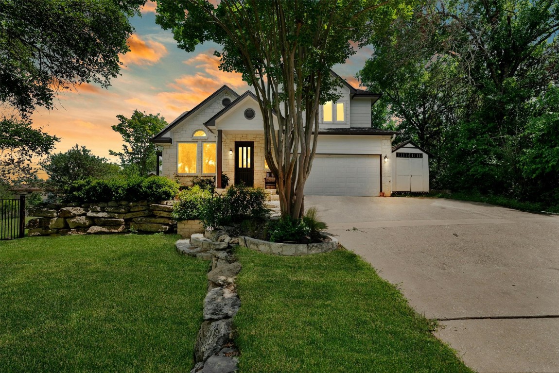 a front view of a house with a garden and trees