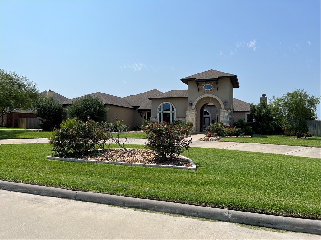 a front view of a house with a garden and yard