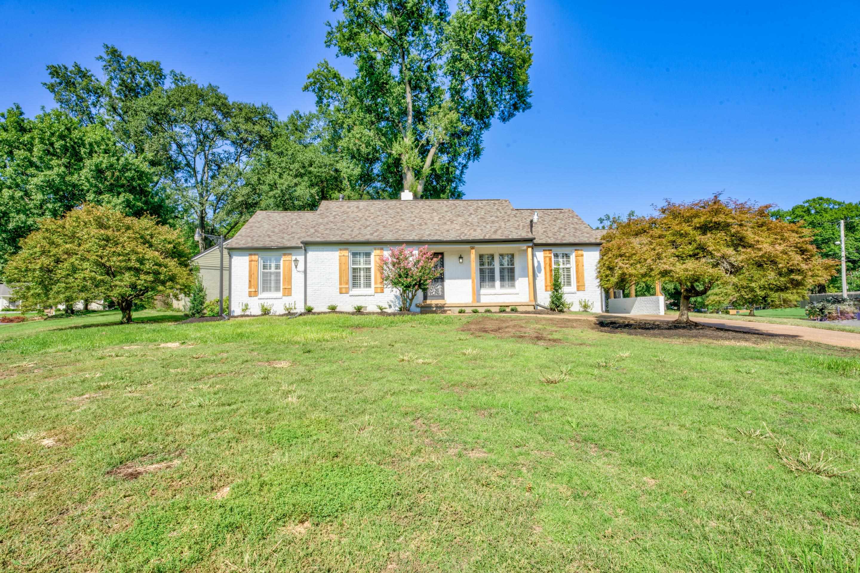 a front view of a house with a garden