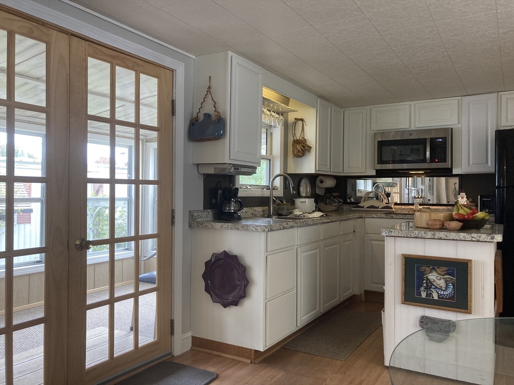 a kitchen with a large window and a white cabinets