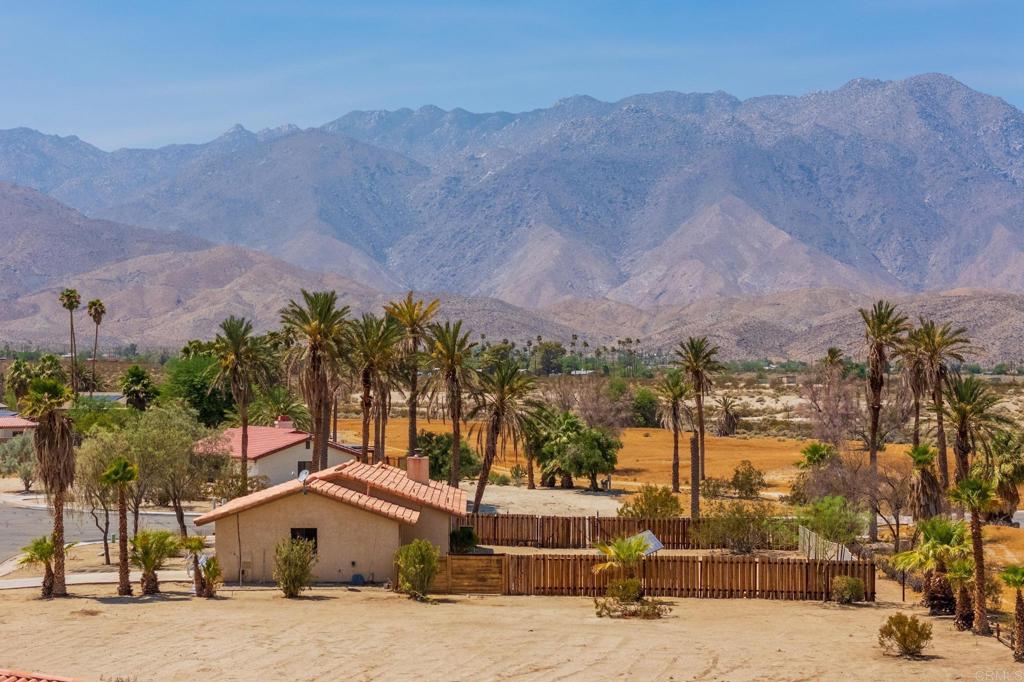 an aerial view of a house with a yard and mountain view