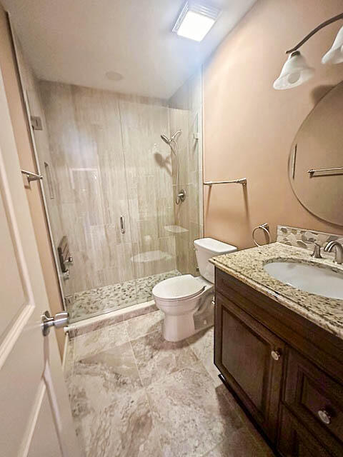 a bathroom with a granite countertop sink toilet and shower