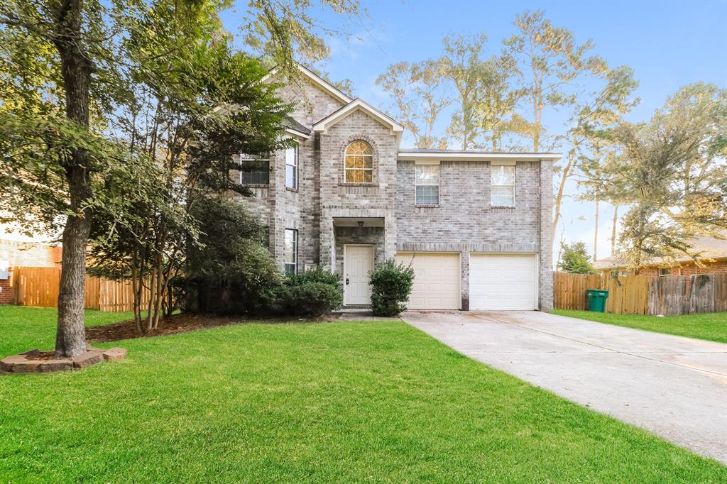 front view of a house with a yard and an trees