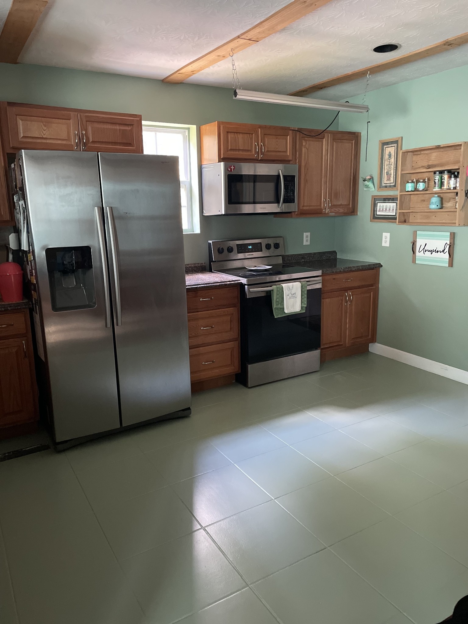 a kitchen with stainless steel appliances a refrigerator a stove a microwave a sink and cabinets