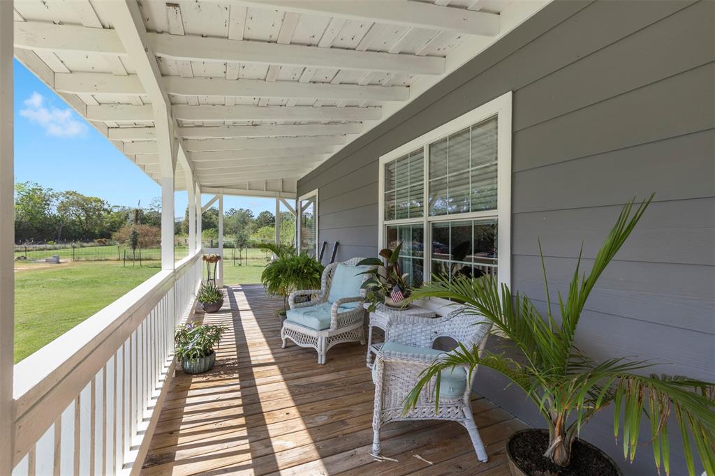 a balcony with wooden floor table and chairs