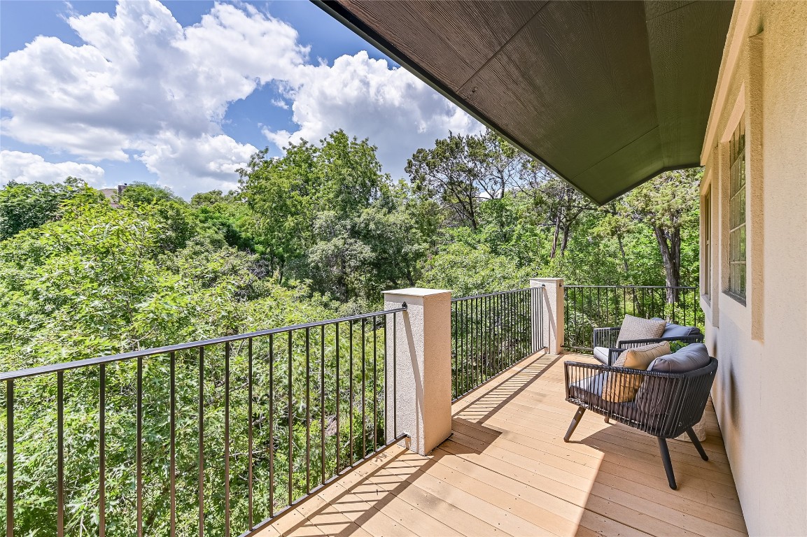 a balcony with wooden floor and outdoor seating