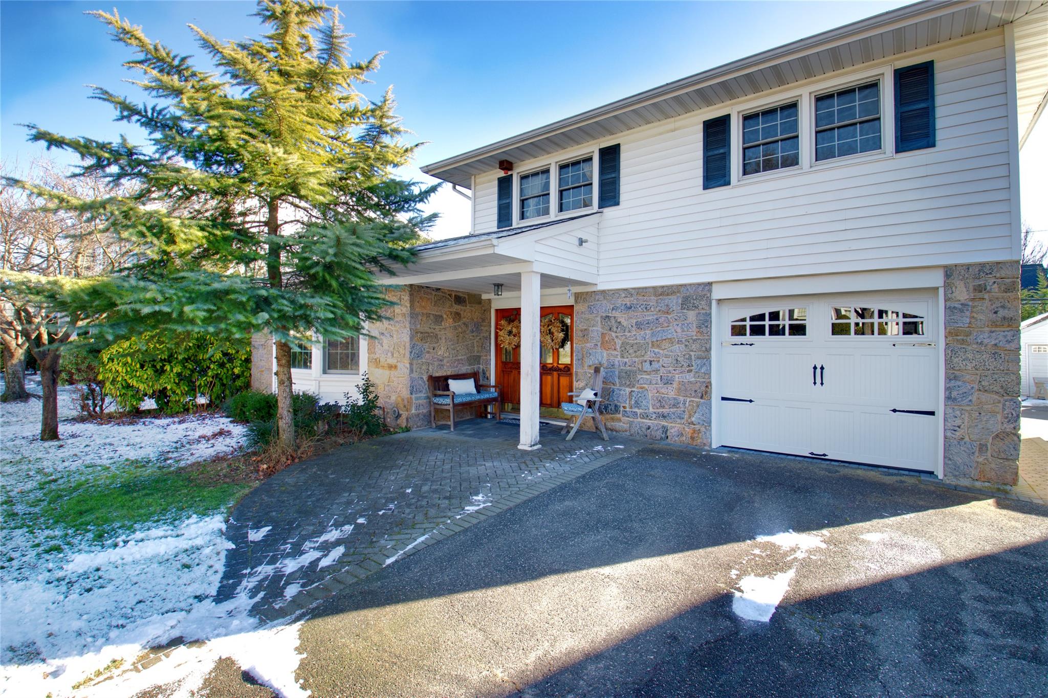 View of front of home with covered double door entry, 1 car garage & double wide driveway