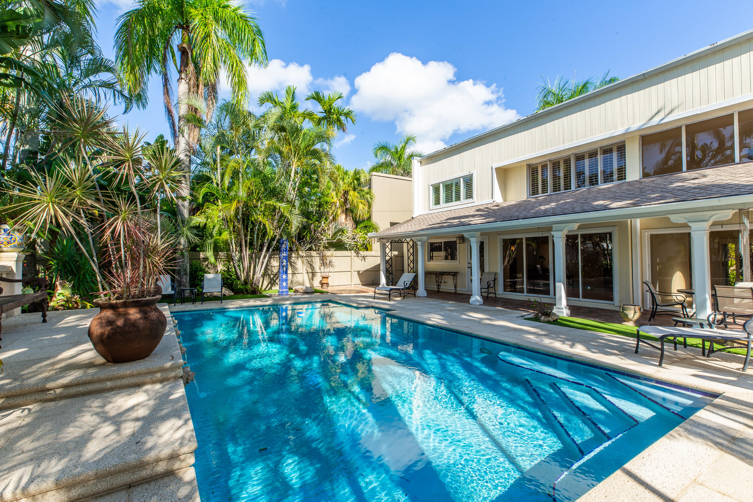 a view of a house with swimming pool and sitting area