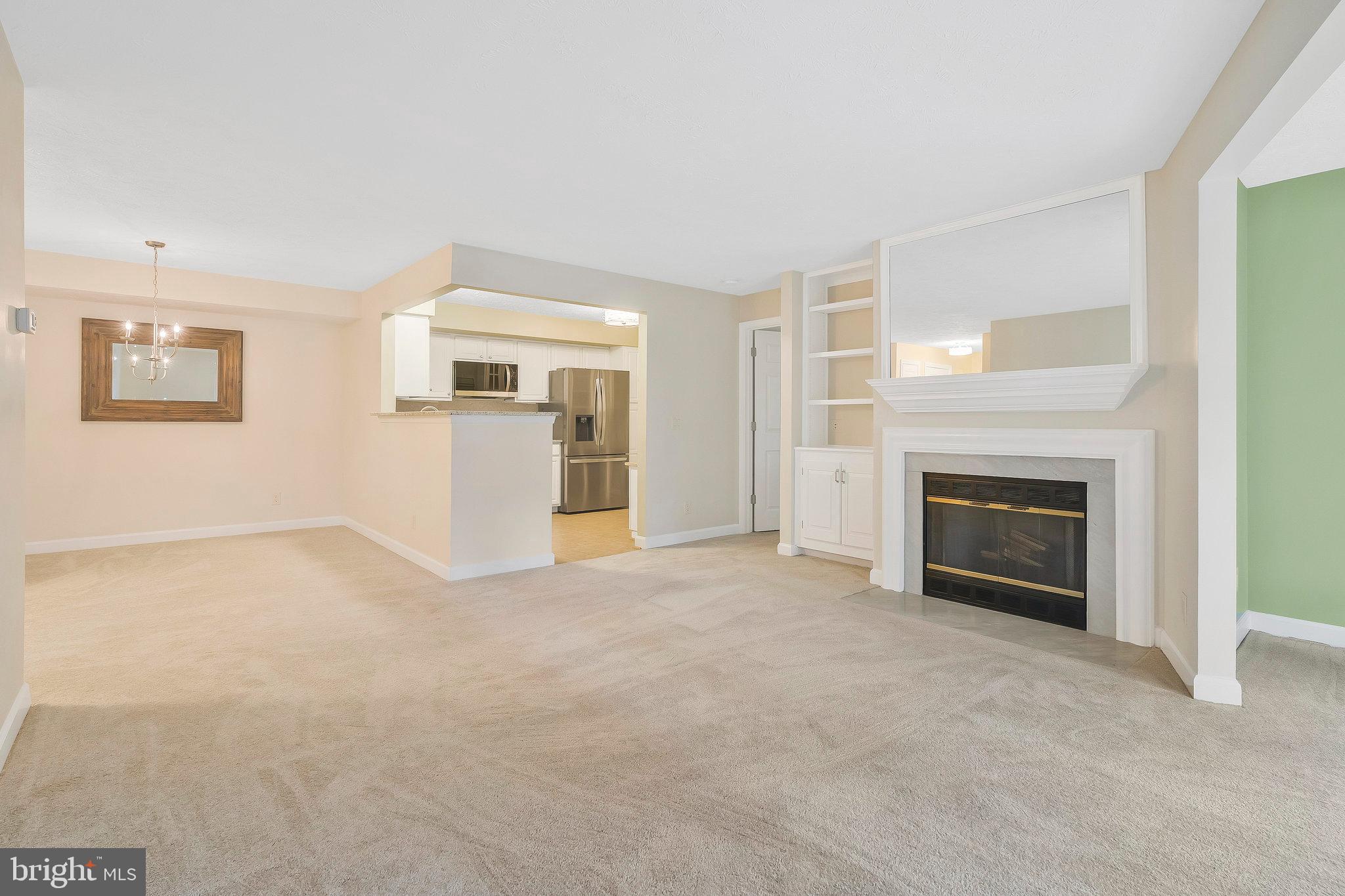 an empty room with windows and fireplace