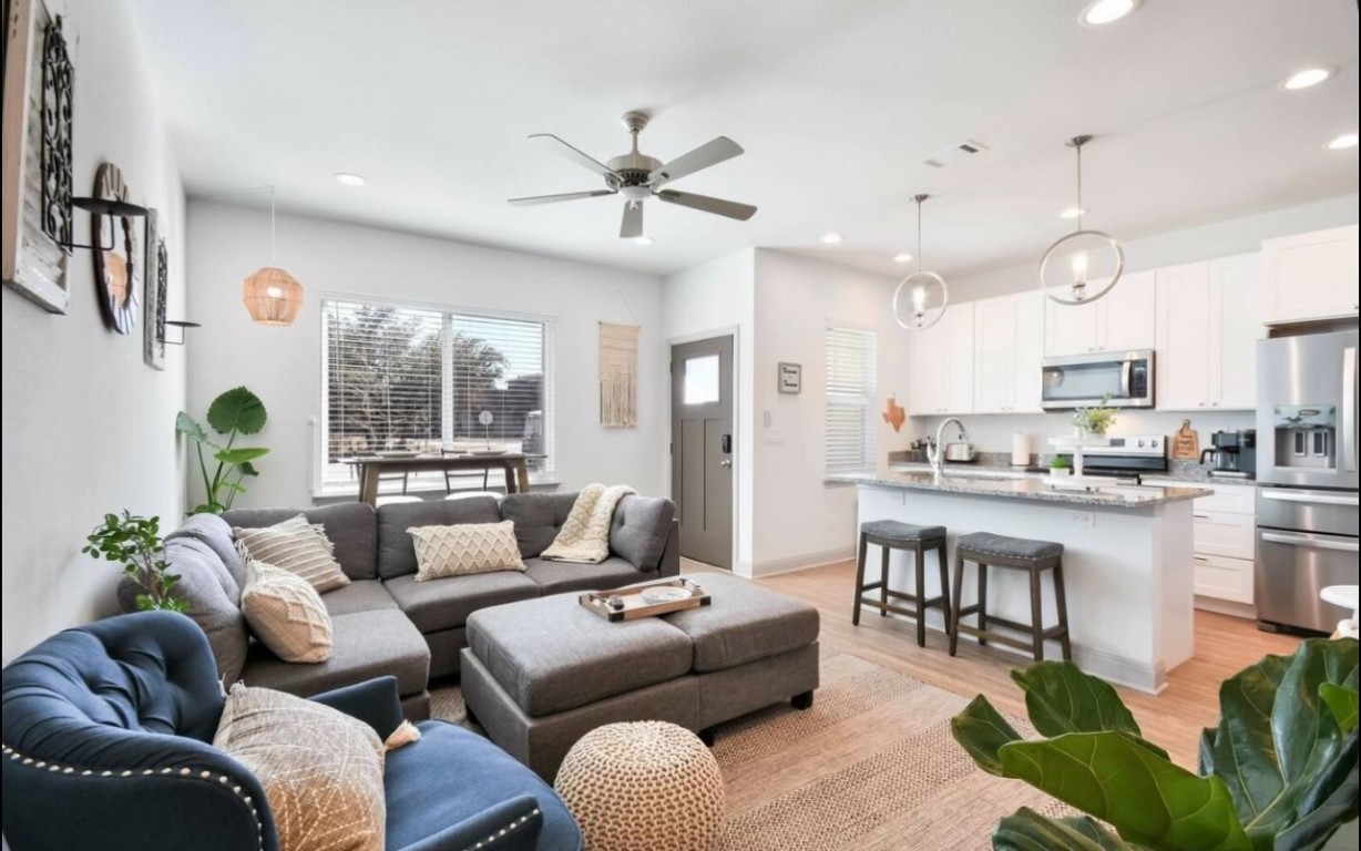 a living room with furniture kitchen and a large window