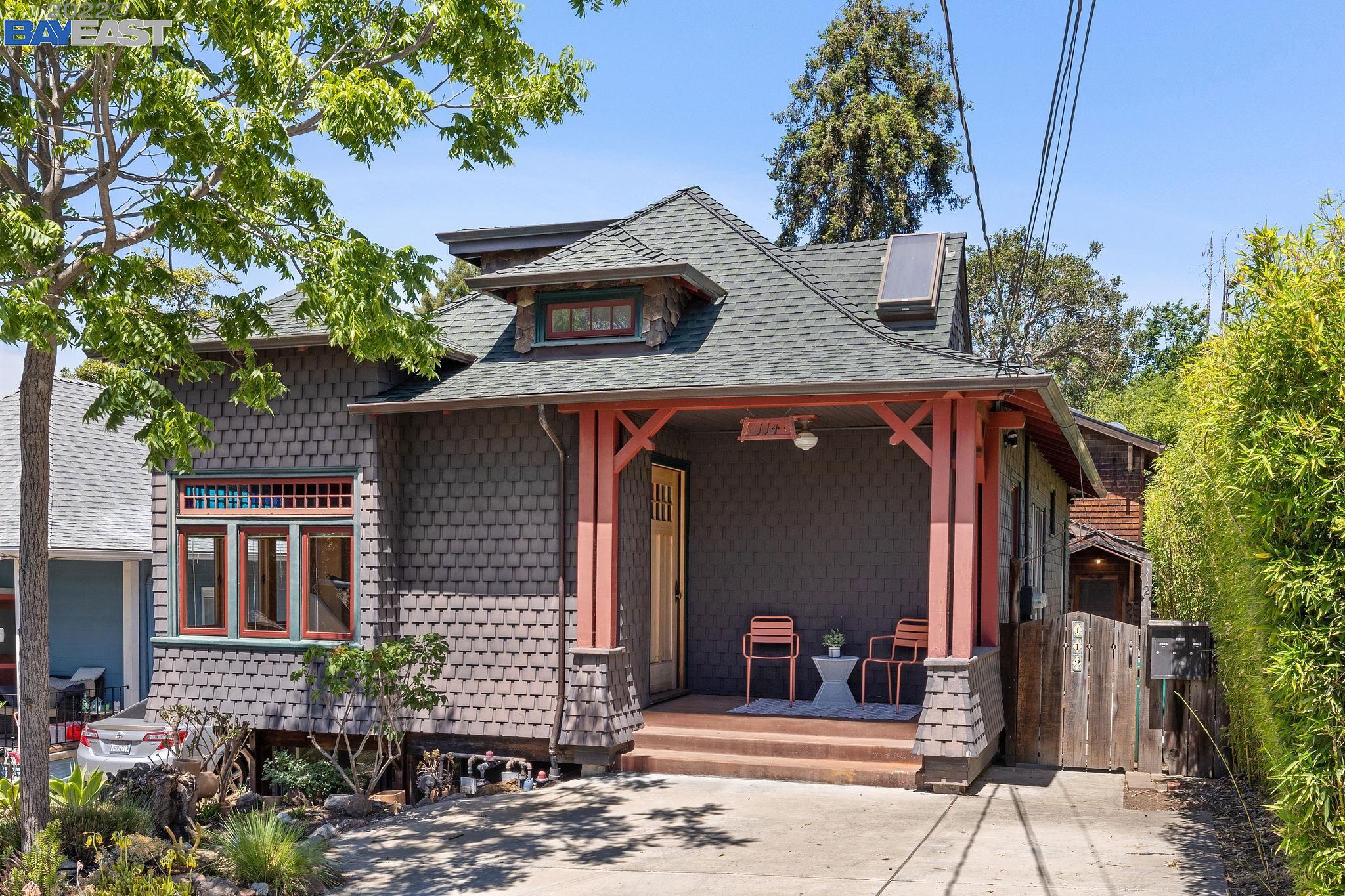 a front view of a house with a tree