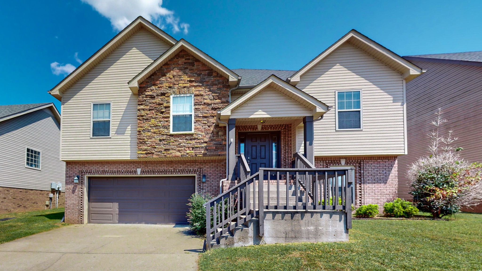 a front view of a house with a yard and deck