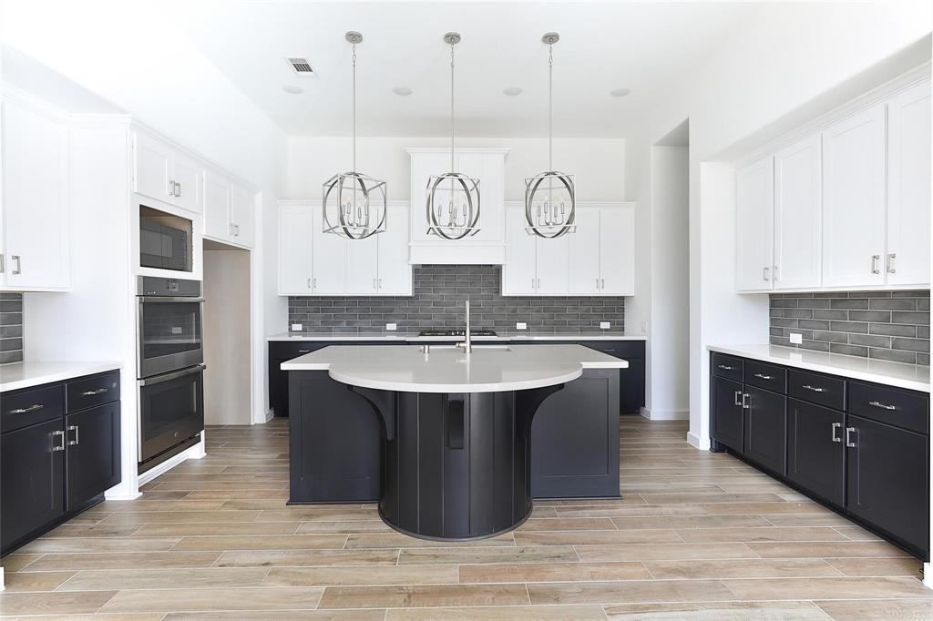 a kitchen with a sink and a stove top oven with wooden floor