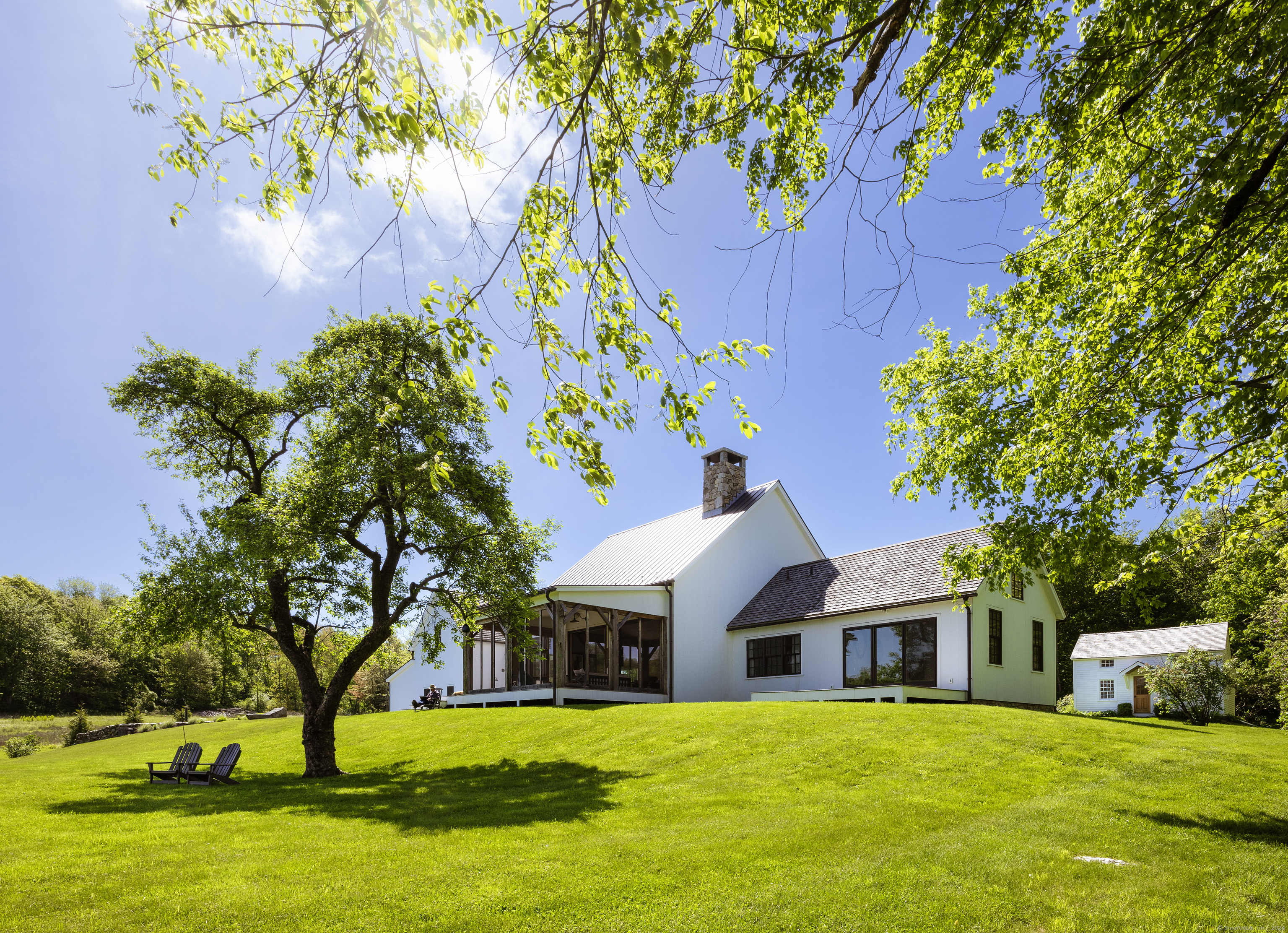 a front view of a house with a yard and trees