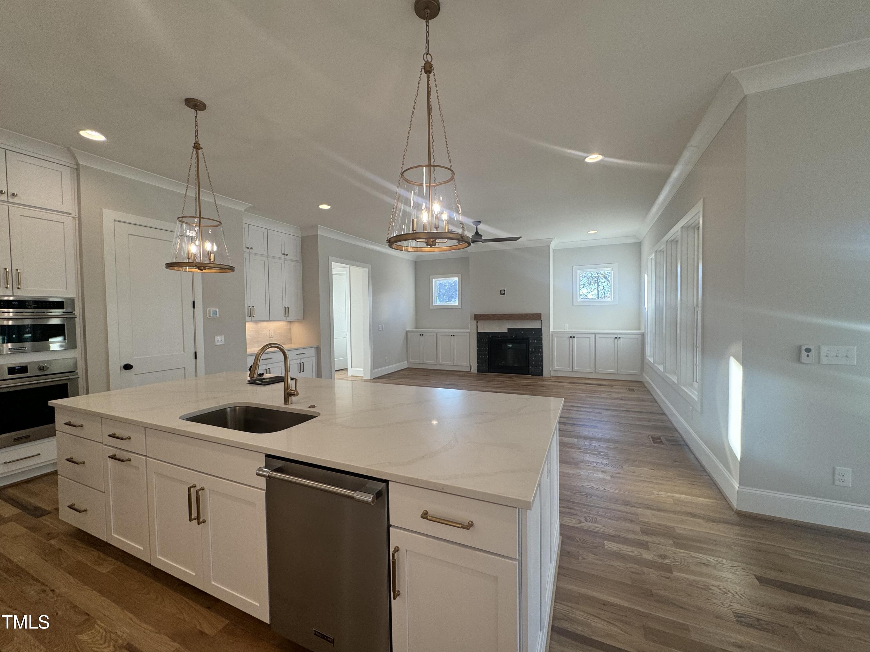 a kitchen with kitchen island granite countertop a sink a counter space appliances and cabinets