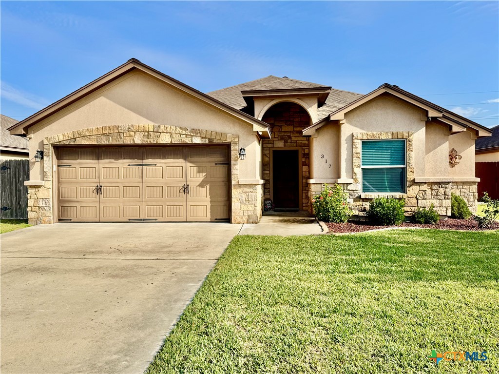 a front view of a house with a yard and garage