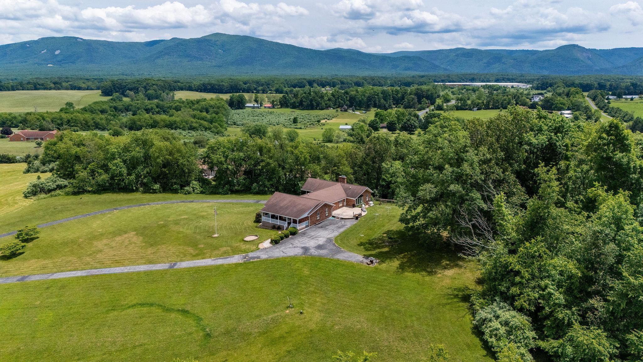 an aerial view of green landscape with trees houses and mountain view