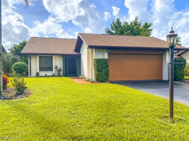 Ranch-style house with a garage and a front yard