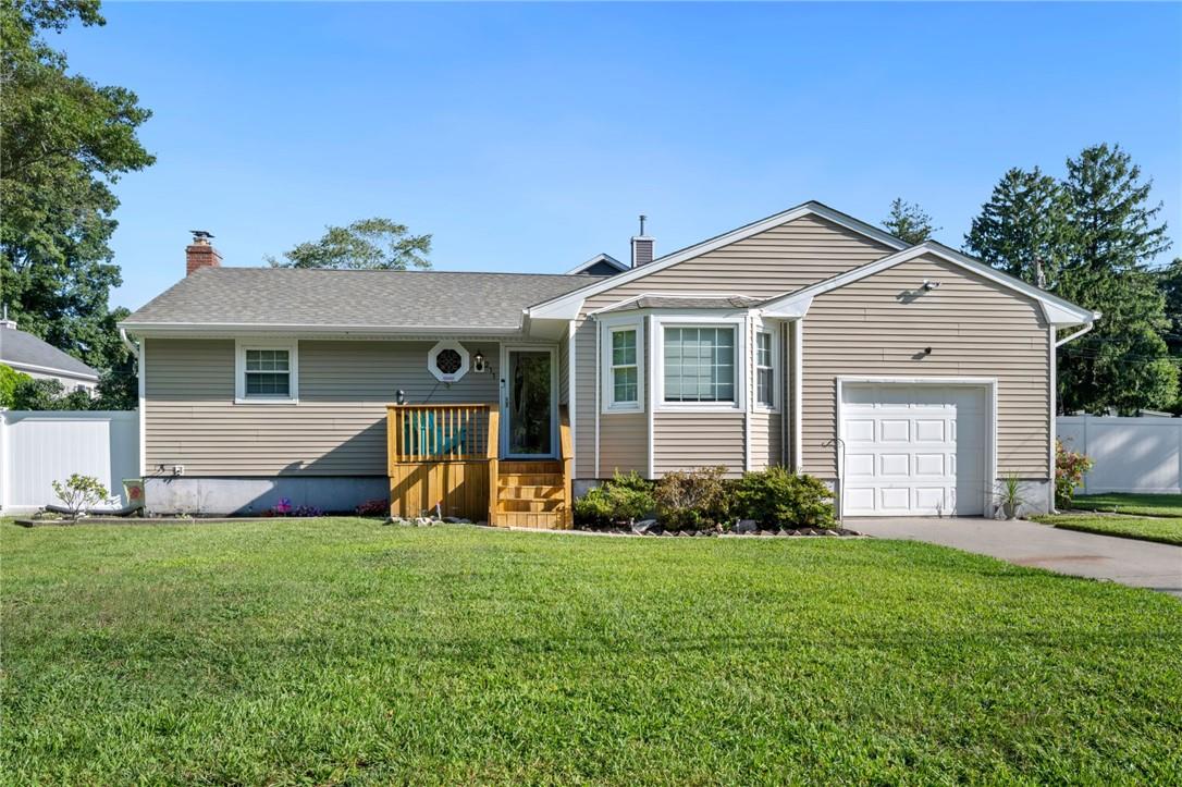 Ranch-style house featuring a garage and a front lawn