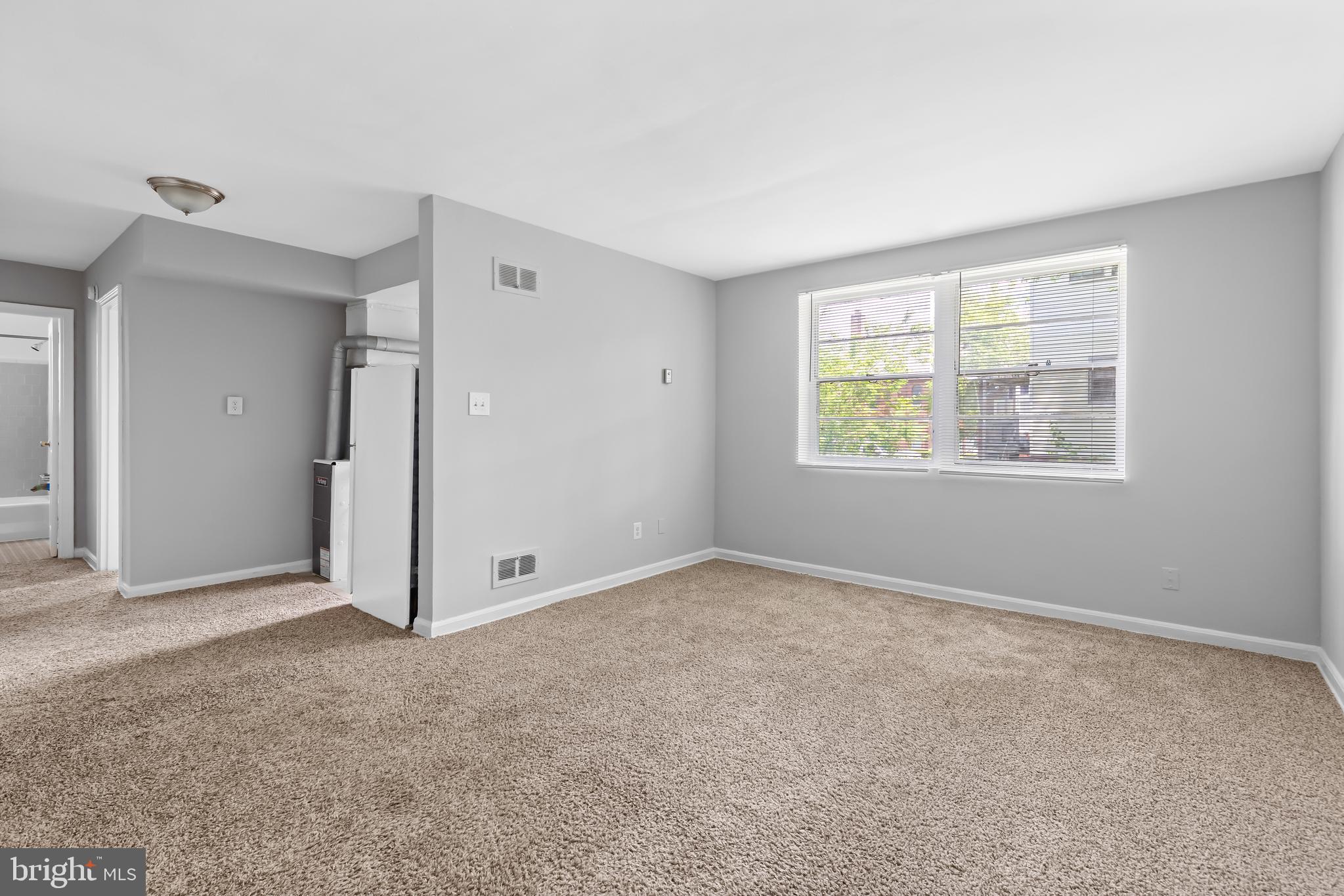 an empty room with windows and closet